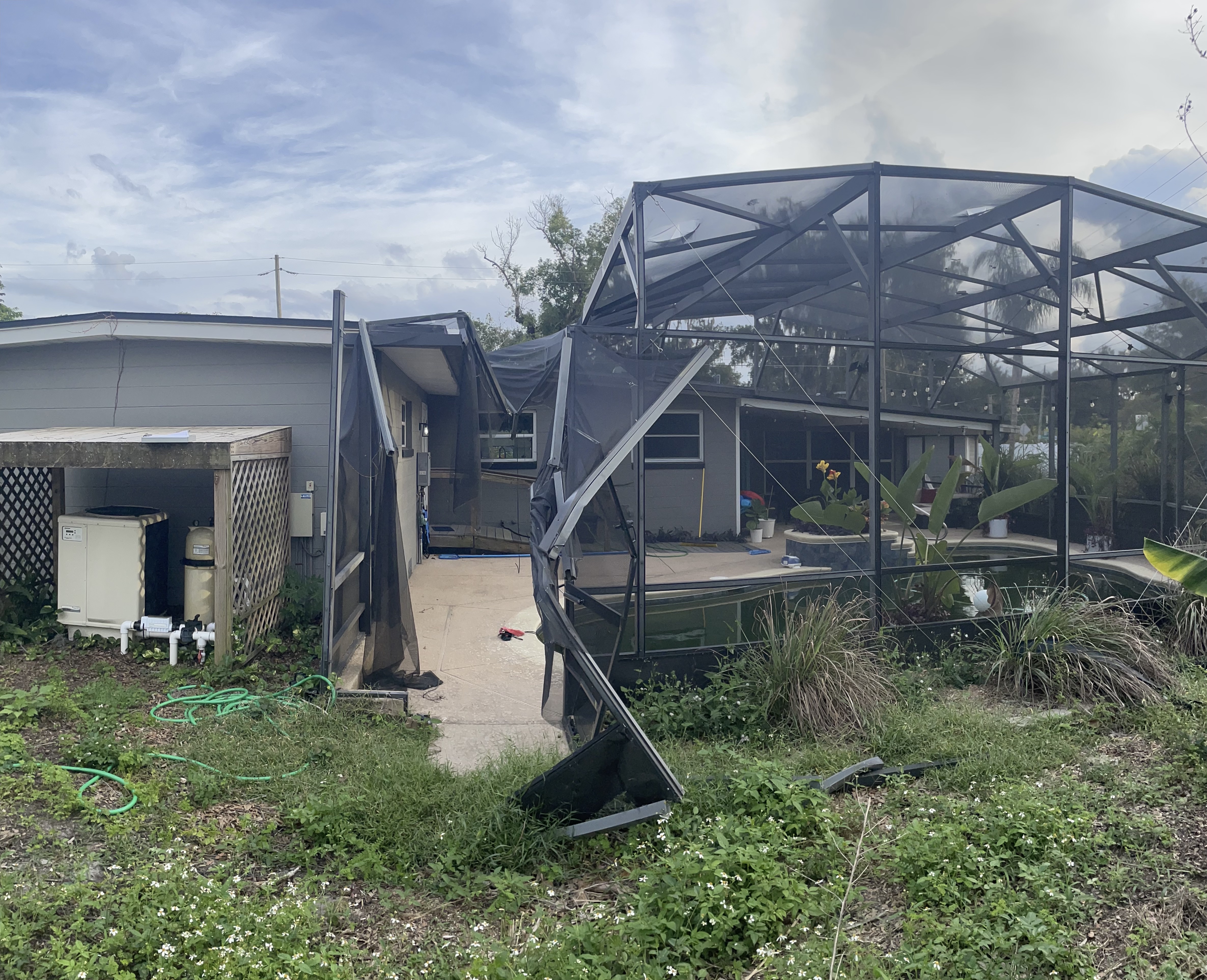 Damaged pool cage screen before repair